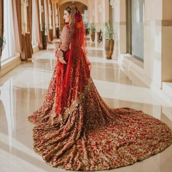 Red long trail wedding lehenga with golden embroidery
