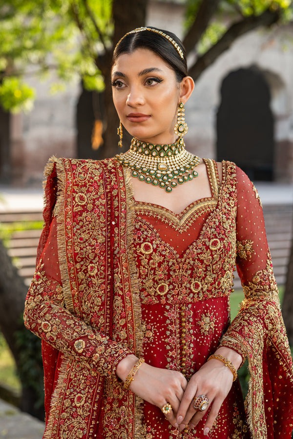 Close-up of red bridal anarkali bodice with gold zari embroidery, sweetheart neckline and kundan choker set Close-up of red bridal anarkali bodice with gold zari embroidery, sweetheart neckline and kundan choker set