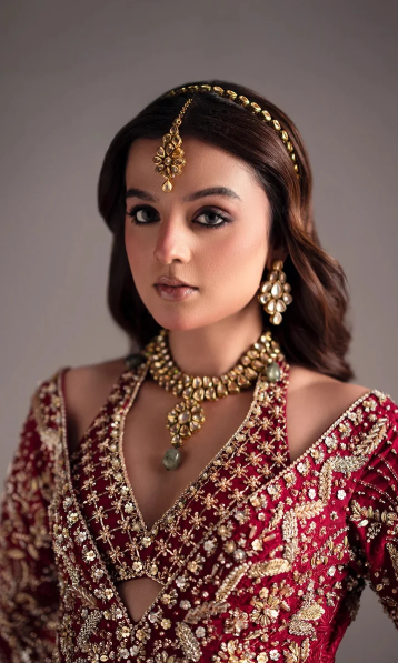 Close-up of a red bridal anarkali lehenga featuring traditional gold embroidery