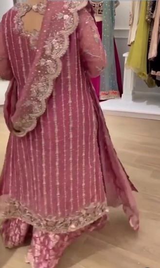 Dusty pink embroidered long Angrakha style suit featuring intricate handwork details paired with flared plazo and matching potli bag