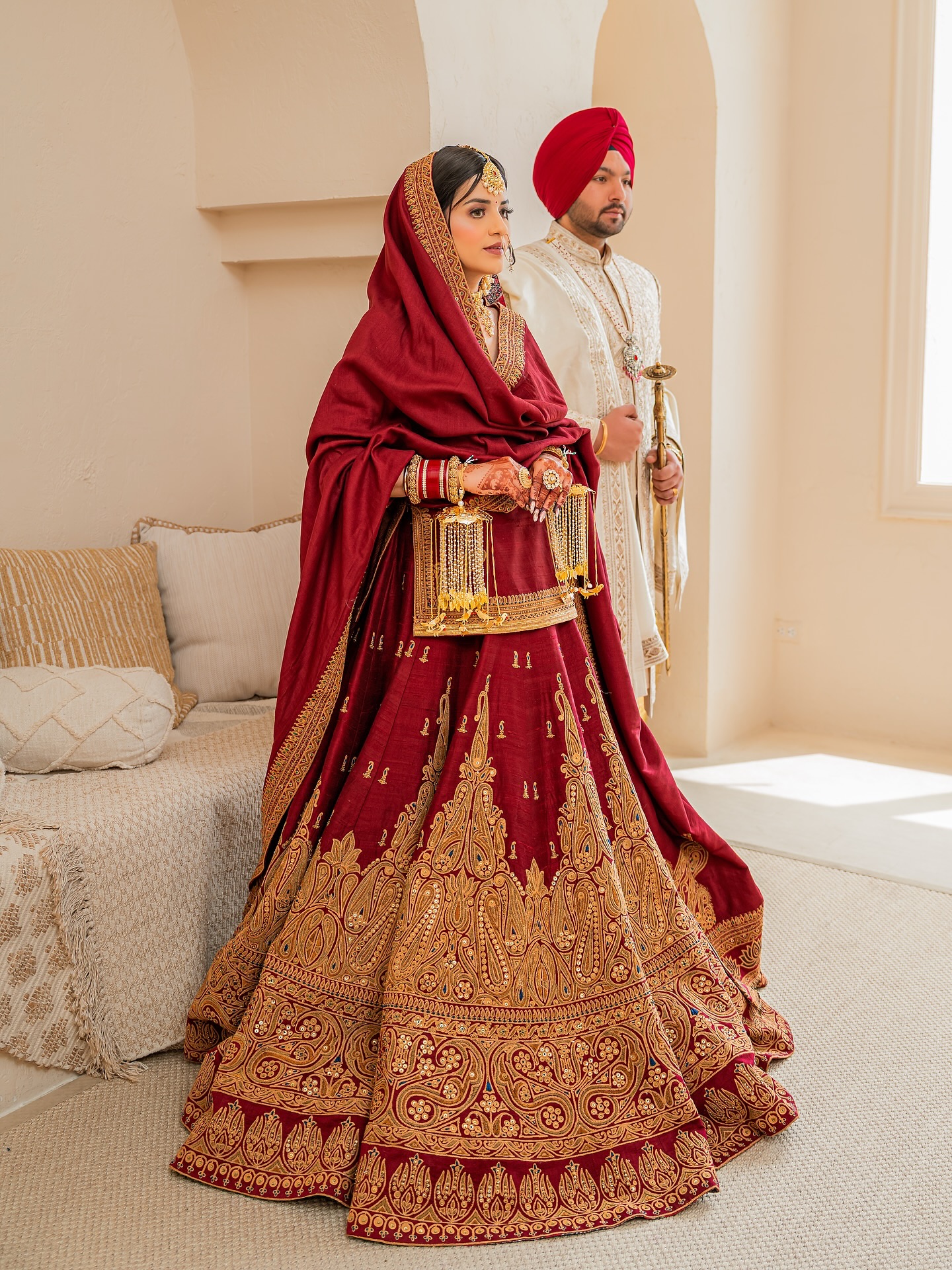 Traditional red Punjabi bride wearing raw silk long choli and lehenga set